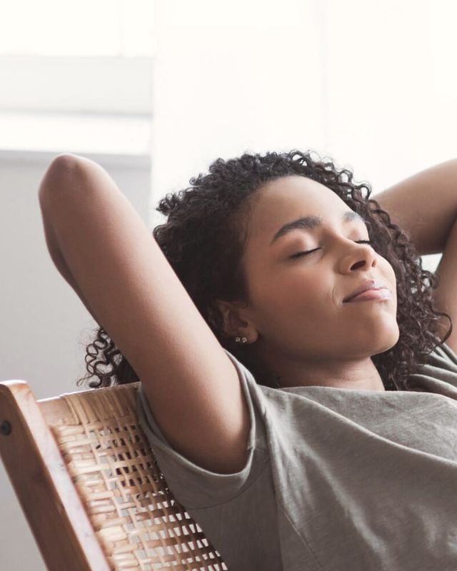 A woman resting in a chair with her eyes closed
